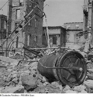 Dresden. Maschinenteile und Rohrleitungen in einem zerstörten Betriebsgelände gegen Ruinen