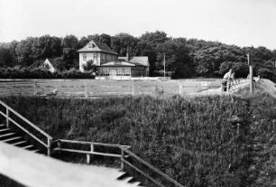 Blick über Treppe zum Strand zu Wohnhäusern und Strand-Halle