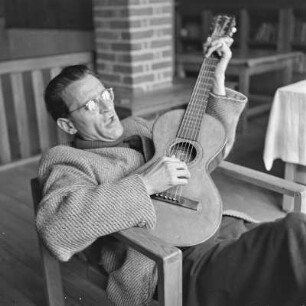 Mann mit Brille spielt Gitarre