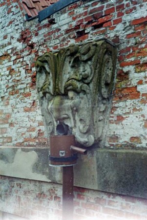 Gut Jersbek: Herrenhaus: Nordgiebel: Sanierung: Detailaufnahme: Wasserspeier Maskaron, darunter Abflussrohr, Gesims
