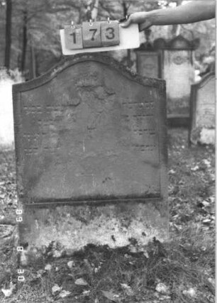 Grabstein 173 (Index: 99609809) Material: Sandstein Zustand: stark verwittert, weitgehender Textverlust Maße HxBxT: 101x67x9 cm Beschreibung: Stele, Konvexbogenabschluß, Schriftfeld eingetieft: Grabstein 173