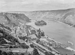 Blick von Süden auf das von Weinbergen umgebene Bacharach mit Bahnhof, Hotel Herbrecht, St. Peter, Wernerkapelle, den sogenannten Hitlerhügel mit Hakenkreuz und den Rhein mit Heyles'en Werth/Bacharacher Werth