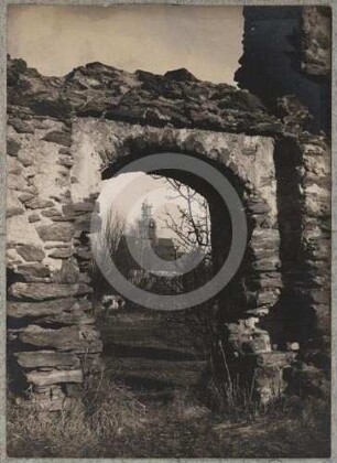 Ruine mit Torbogen und Durchblick zur katholischen Kirche Faulbrück