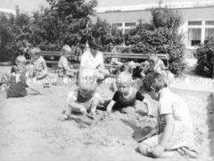 Spielende Kindergartenkinder im Sandkasten