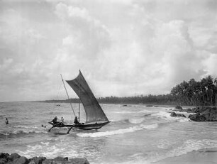 Colombo. Einheimische in einem Segelboot und Badende am Strand
