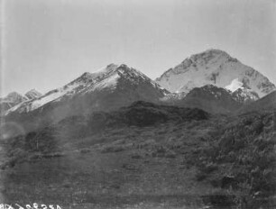 Gipfel : Blick über einen Berghang auf schneebedeckte Gipfel im Tian Shan Hochgebirge