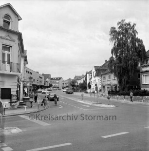 Bahnhofstraße: vorne links Einmündung von Mahlmannstraße: Verkehrsinseln, Ampelanlage, Straßengeländer: Autos, Mopedfahrer: Fußgänger: in Bahnhofstraße links Kaufhaus Käselau