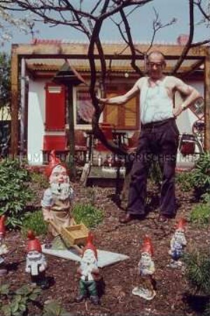 Rentner mit Gartenzwergen im Kleingarten