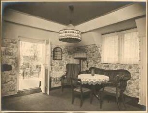 Landhaus Dr. Petz, Berlin-Nikolassee: Innenaufnahme Balkonzimmer mit Sitzgruppe mit Blick auf Balkon durch geöffnete Tür