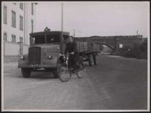 Ein junger Mann fährt mit dem Fahrrad an einem LKW vorbei