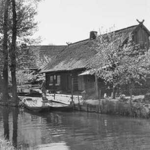 Strohgedecktes Blockhaus in Lehde mit Anlegerstelle. : Ze słomu kryta kładźita chěža w Lědach z přistawnišćom.