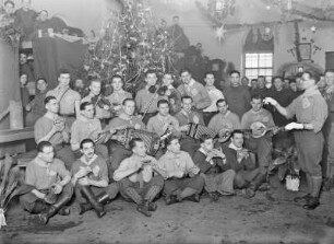 Weihnachtsfeier französischer Kriegsgefangener in einer Turnhalle. Instrumentalgruppe mit Dirigenten