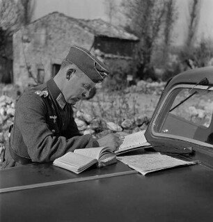 Hans-Adalbert von Stockhausen schreibt auf dem Kühler des Autos (Aufnahme im Rahmen der Fotokampagne im besetzten Frankreich)