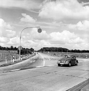 B 404: Ende der Ausbaustrecke: vorn Einmündung in Möllner Landstraße: rechts VW-Käfer: hinten rechts und links Weiden mit Rinderherden