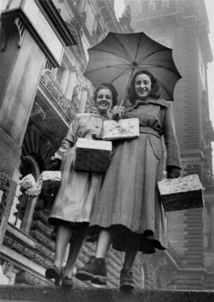 Die ersten Weihnachtseinkäufe nach der Währungsreform 1948. Nun gibt es wieder alles. Die zwei Frauen sind mit Päckchen beladen
