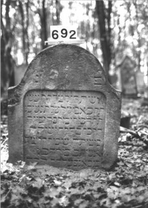 Grabstein 692 (Index: 99900516) Material: Sandstein Zustand: leicht angewittert Maße HxBxT: 85x67x10 cm Beschreibung: Stele mit Konvexbogenabschluss, eingesunken: Grabstein 692