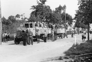 Männer und Frauen vor einem Wagen der Möbelspedition Rudolf aus Dohna auf dem Weg zu der Kundgebung der KPD in Dresden-Reick am 19. Juli 1932