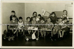 Kindergartenkinder mit Büchern und Olympiafähnchen
