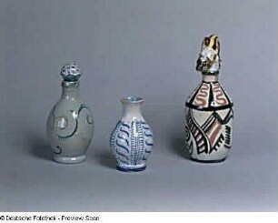 Zwei Flaschen und Vase : Zwei Flaschen (rechts mit bärtigem Männerkopf als Stöpsel) und Vase. Fayence, bemalt, glasiert (um 1925; K. Feuerriegel). Museum im Schloß Frohburg V 551/96, V 552/96, V 553/96