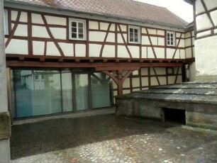 Stadtbild-Ansicht im Südsüdwesten-ehenmalige Stadtmauer am Kirchhof der Stadtkirche mit Fachwerkverkleidung sowie ausgebautem ehemaligem Wehrgang