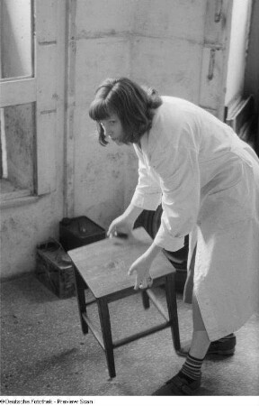 Renate Rössing beim Rücken eines Hockers