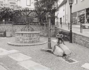 Ehemaliger Ziehbrunnen, Handschwengelpumpe und Brunnenplastik