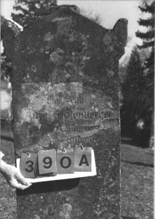Grabstein 390 (Index: 99786171) Zustand: obere Hälfte abgebrochen und zementiert, Inschrifttafel fehlt, Rückseite leicht verwittert Maße HxBxT: 173x57x26 cm: Grabstein 390A