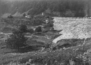 Felsige Landschaft : Blick auf eine felsige Hochebene, rechts ein gesicherter Hang, auf dem eine Straße entlang führt. Im Hintergrund eine Postsäule