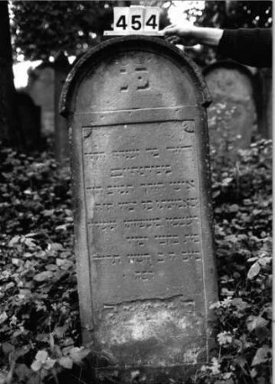 Grabstein 454 (Index: 99803741) Material: sandstein Zustand: unten abgeblättert Maße HxBxT: 130x51x10 cm Beschreibung: Stele mit verdachtem Rundbogen, profilierter Rand, Giebelfeld: Grabstein 454