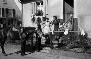 Freiburg; St. Georgen: St. Georgsritt; Reiter neben Pferd an Hausaufgang