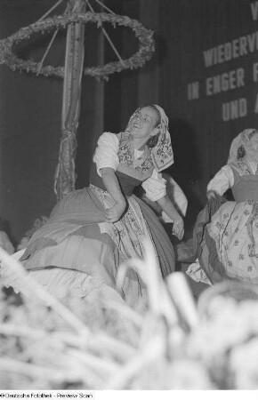 Tanzende Frauen in Tracht bei einer Veranstaltung zum Gedenken an die Völkerschlacht, im Hintergrund ein Maibaum