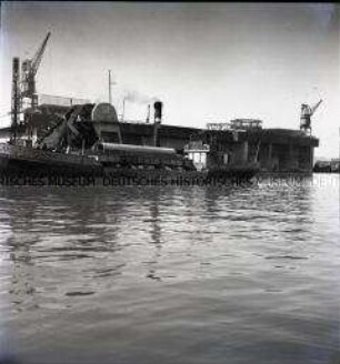 Schiff ankert vor einem deutschen Großbunker für U-Boote in einem Hafen an der französischen Atlantikküste