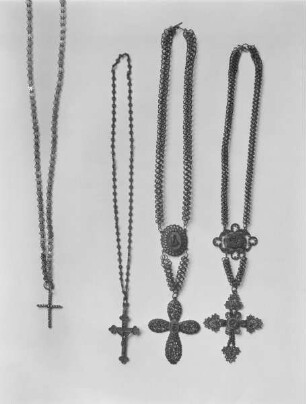 Vier Kettchen mit Kreuzanhängern. Von links nach rechts: Kreuz aus poliertem Stahl, Kgl. Eisengießerei Berlin. Kreuz an dünner Kette, Kgl. Eisengießerei Gleiwitz. Filigrankreuz mit Allegorien. Kgl. Eisengießerei Berlin und Kreuz mit Vierungsmedaillon, Kgl. Eisengießerei Berlin