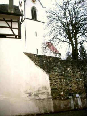Ansicht von Süden aus dem Ort mit (Gotischem) Kirchturm über Kirchhofmauer im höher gelegenen Kirchhof