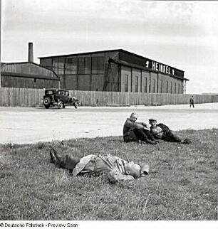 Rostock-Warnemünde. Ernst Heinkel Flugzeugwerke Warnemünde. Ansicht der Werkhalle. Im Vordergrund Arbeiter während der Pause