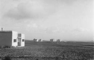 Siedlung : Weiße Gebäude einer Siedlung inmitten einer ebenen Landschaft