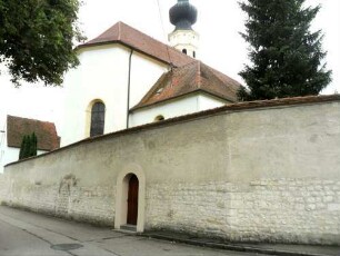 Ansicht von Ostnordosten mit Kirche (im Kern 15 Jh - Langhaus im 18 Jh erhöht) über Kirchhofmauer (Steinbrüstung mit Schießscharten im 18 Jh glatt verputzt) von Feldseite