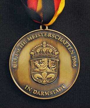 Bronzemedaille Deutsche Meisterschaften in Kurzschrift und Maschinenschreiben in Darmstadt 1986 am schwarz-rot-goldenen Band : Sammlung Deutscher Stenografenbund. Bronzemedaille Deutsche Meisterschaften in Kurzschrift und Maschinenschreiben in Darmstadt 1986 am schwarz-rot-goldenen Band. Messing, patiniert; Durchmesser 50 mm, Gewicht 39 g (1986; Deschler & Sohn, München). Dresden: SLUB R c 0544