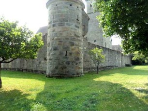 Nordwest-Rundturm (verschiedene Schießscharten) mit Kirchhofmauer nach Norden und Westen über Grabenvorfeld von Feldseite
