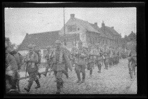 Nicht identifizierbare Ortschaft in Nordfrankreich oder Belgien: Trupp Soldaten mit Pickelhaube, geschultertem Gewehr und voller Marschausrüstung auf einer gepflasterten Straßenbrücke mit schmiedeeisernem Geländer (Nahaufnahme)