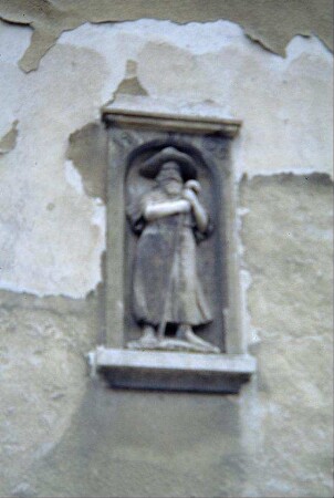 Figur am ehemaligen Schulhaus: Der Mann mit dem Muschelhut (unscharf)