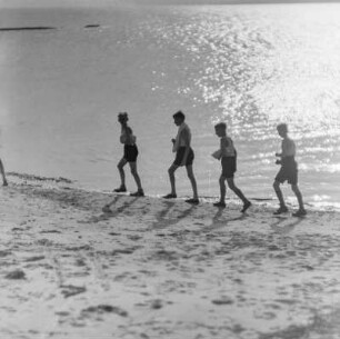 Jugendliche laufen am Strand entlang