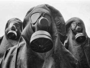 Drei Soldaten mit Gasmasken während des NATO-Manövers Flinker Igel, an dem 52.000 Soldaten aus verschiedenen NATO-Staaten teilnahmen, um nukleare und konventionelle Kampfsituationen zu simulieren, Bayern