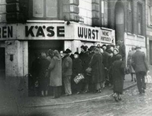 Hamburg. Hungerwinter 1946/1947. Menschen stehen an einem Lebensmittelgeschäft an. "Vierfache" Wurst ist aufgerufen