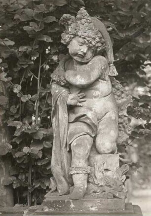 Putto: Dezember : Putto im Ehrenhof (Ostrand), Kind mit Pelz und brennendem Holz, Höhe 1,20m