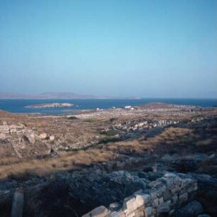 Delos. Blick vom Kynthos zum Heiligen Hafen auf Ríneia und (im Dunst) auf Tinos. Knapp 4 km. K1