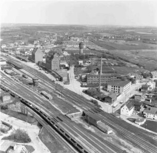 Bahnhofsgelände (Turmstraße): Luftbild: im Vordergrund Bahnstrecke Hamburg-Lübeck mit Unterführung am Pölitzer Weg, im Hintergrund Wasserturm und Silos und Firmengebäude von Johannes Ströh Gloria Mehl