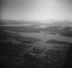 Luftbildaufnahme von Kristiansund : Luftbildaufnahme einer Stadt, vermutlich die Hafenstadt Kristiansund nach der Zerstörung durch deutsche Marineeinheiten 1940. Im Hintergrund vermutlich die Berge der Insel Averøy.