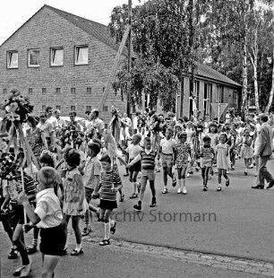 Kindervogelschießen: Bei den Rauhen Bergen / Wöhrendamm: Festumzug: Klasse mit Blumenbügeln und Blumenstöcken: rechts und links Zuschauer: hinten Waldreitersaal: davor Bäume