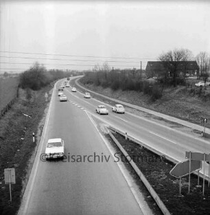 Nütschau: Bundesstraße B 404: Ausflugsverkehr: hinten Pkws: vorn Mitte Ausfahrt: hinten rechts Gebäude und Schrottautos: 9. April 1971